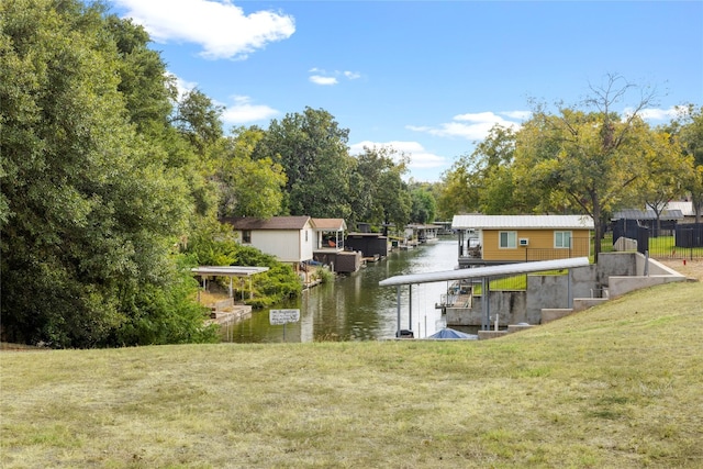 view of dock with a yard and a water view