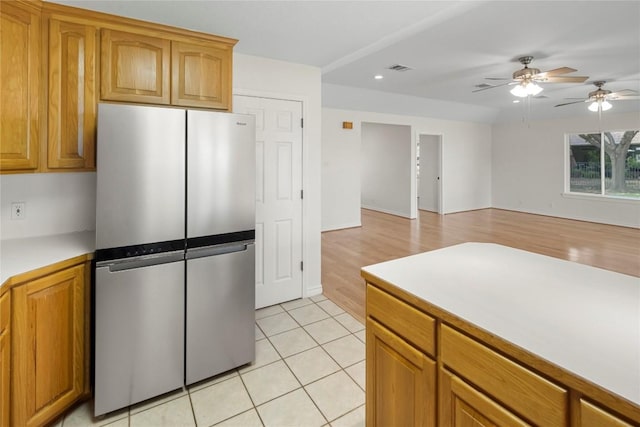 116 Wren St, Highland Haven, TX 78654 - kitchen featuring freestanding refrigerator, light countertops, a ceiling fan, light tile patterned flooring, and brown cabinetry
