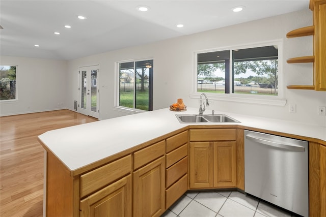 kitchen with stainless steel dishwasher, light wood-type flooring, sink, and a wealth of natural light