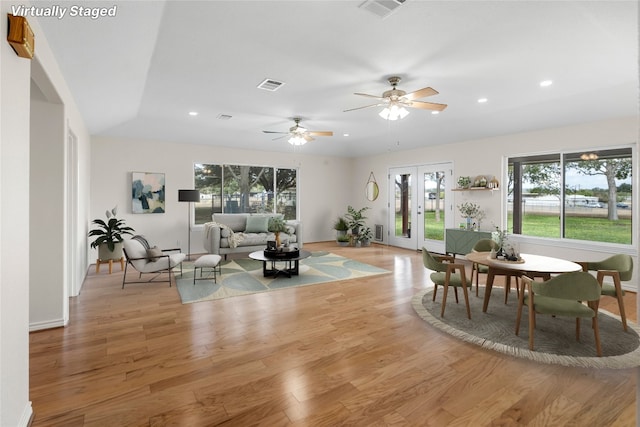 living room featuring ceiling fan, french doors, and light hardwood / wood-style flooring