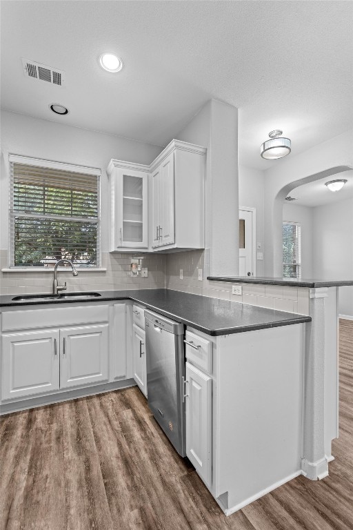 kitchen with a wealth of natural light, stainless steel dishwasher, dark hardwood / wood-style floors, and white cabinets