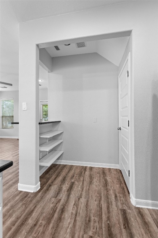 spacious closet featuring lofted ceiling and dark hardwood / wood-style floors