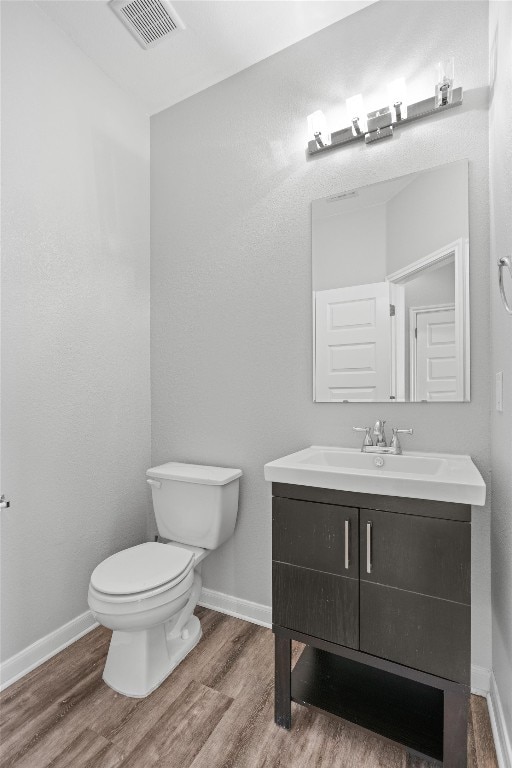 bathroom featuring vanity, hardwood / wood-style flooring, and toilet