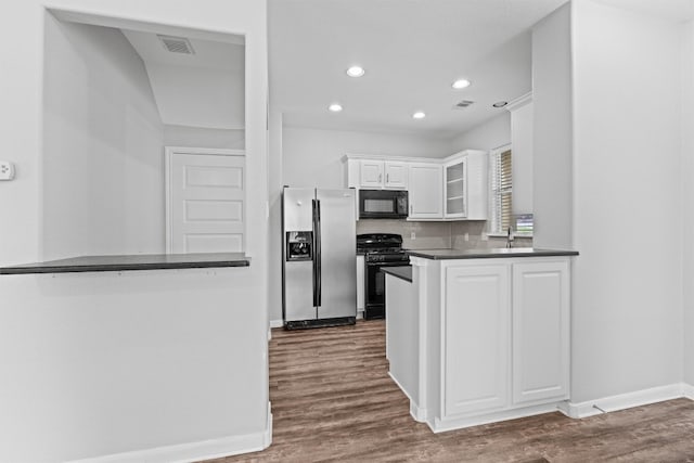 kitchen featuring dark hardwood / wood-style floors, kitchen peninsula, black appliances, white cabinets, and tasteful backsplash