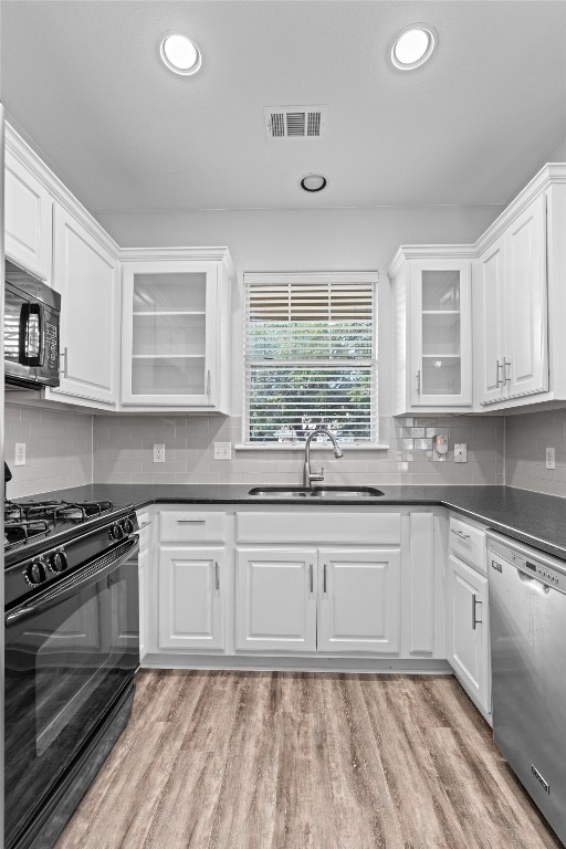 kitchen featuring white cabinetry, black appliances, and sink