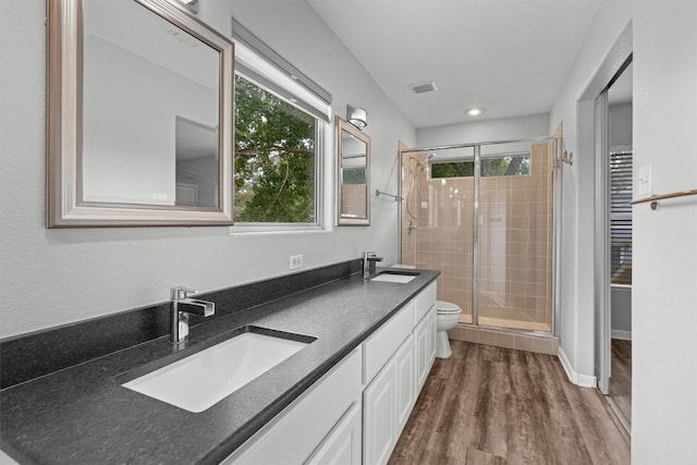 bathroom featuring toilet, walk in shower, vanity, and wood-type flooring