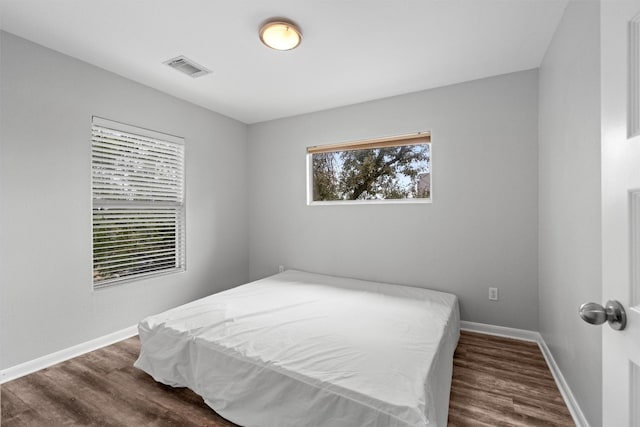 bedroom with dark hardwood / wood-style flooring