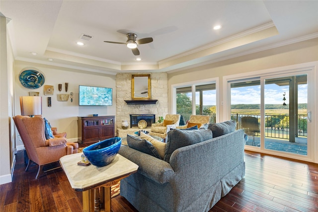 living room featuring a raised ceiling, ceiling fan, dark hardwood / wood-style flooring, and ornamental molding