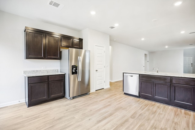 kitchen with sink, dark brown cabinets, stainless steel appliances, and light hardwood / wood-style floors