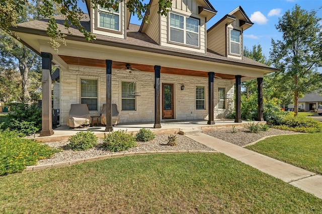 302 Columbine St, Marble Falls, TX 78654 - view of front of house featuring a front yard, a porch, ceiling fan, stone siding, and board and batten siding