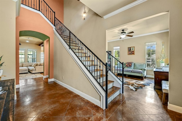 stairway featuring ceiling fan and ornamental molding