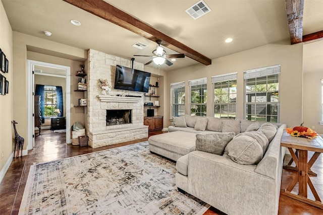 tiled living room with beam ceiling, a stone fireplace, and ceiling fan