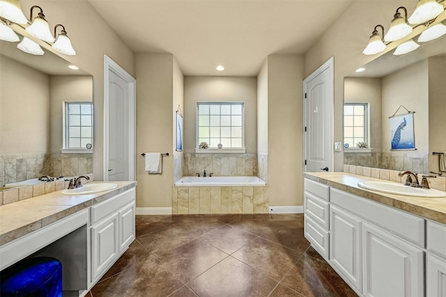 bathroom featuring vanity, tile patterned flooring, and a relaxing tiled tub