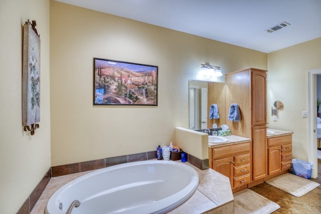 bathroom with tile patterned flooring, vanity, and a tub