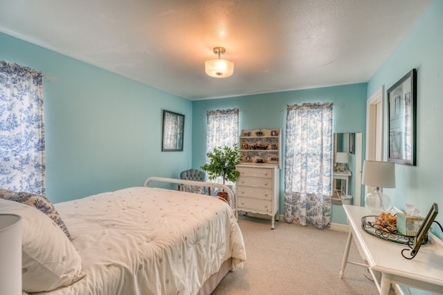 bedroom featuring a textured ceiling and light carpet