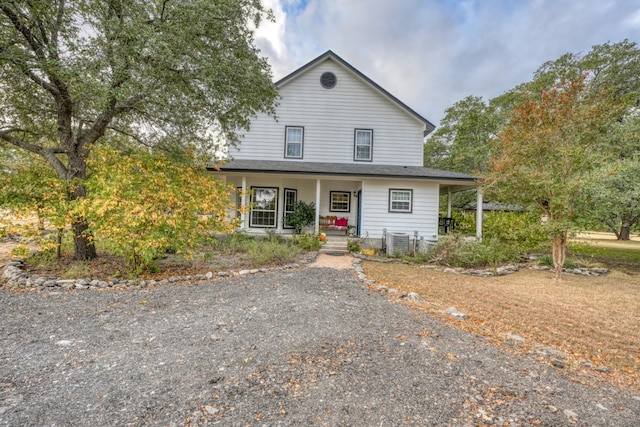 farmhouse-style home with central air condition unit and covered porch