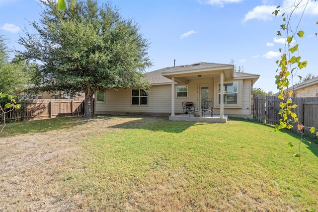 back of property with a patio and a yard