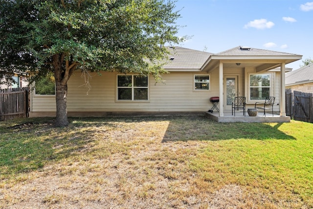 back of house featuring a patio and a lawn