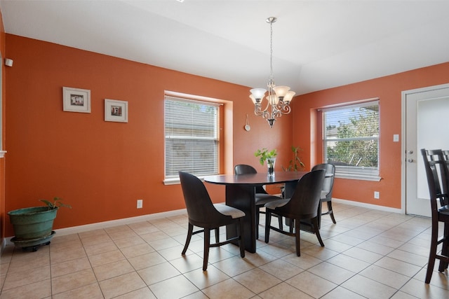 dining space featuring light tile patterned flooring and a chandelier