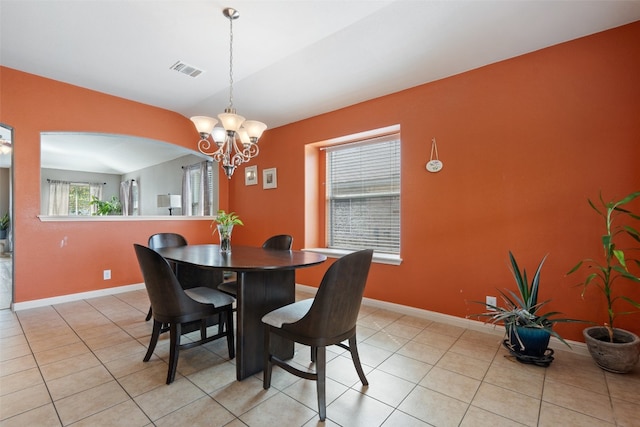 dining space featuring lofted ceiling, a chandelier, and light tile patterned floors