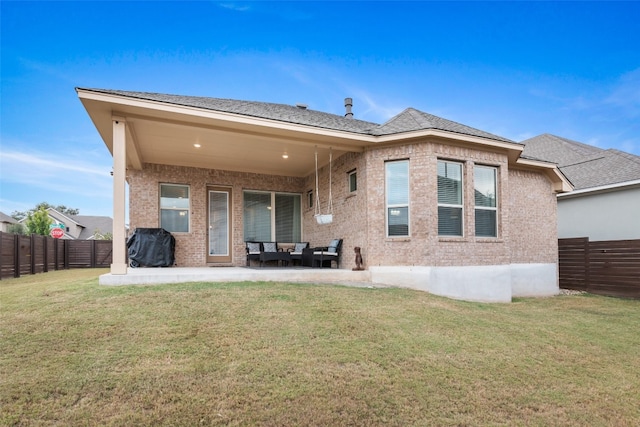 rear view of property featuring a yard and a patio area