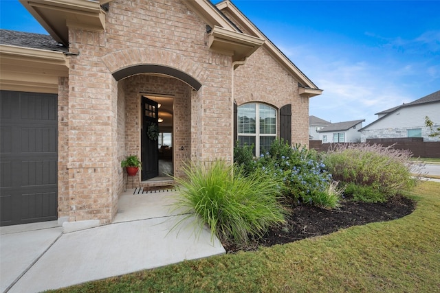 property entrance with a garage and a lawn