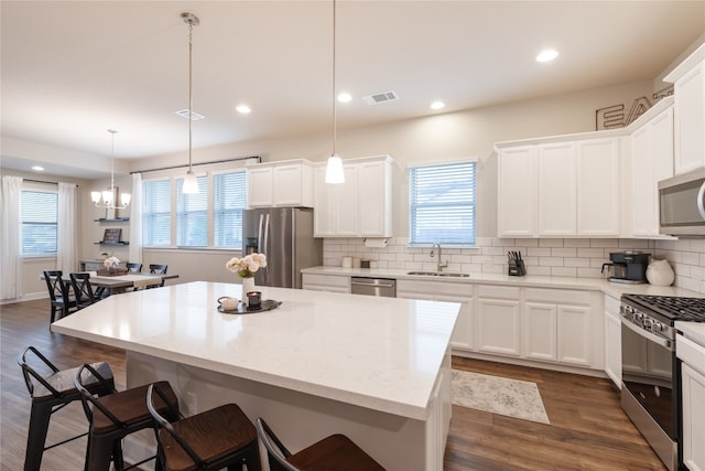 kitchen featuring a center island, appliances with stainless steel finishes, and hanging light fixtures