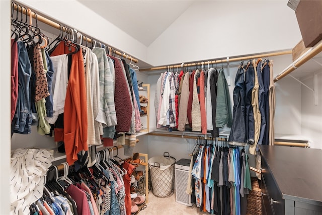 walk in closet with carpet and lofted ceiling