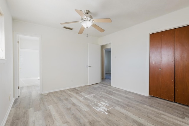 unfurnished bedroom with a closet, ceiling fan, light hardwood / wood-style flooring, and ensuite bath