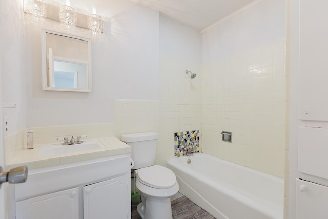 full bathroom with tiled shower / bath, vanity, hardwood / wood-style flooring, and toilet