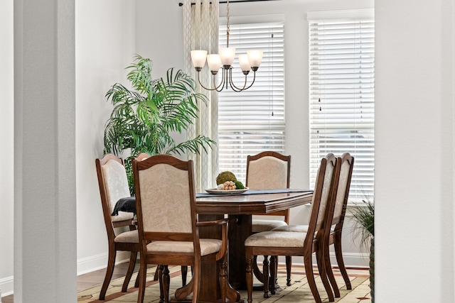 dining room featuring a healthy amount of sunlight, light hardwood / wood-style floors, and a chandelier