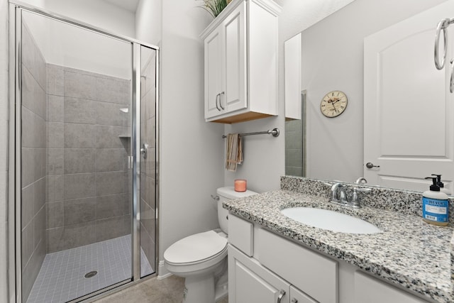 bathroom with toilet, tile patterned floors, a shower with shower door, and vanity