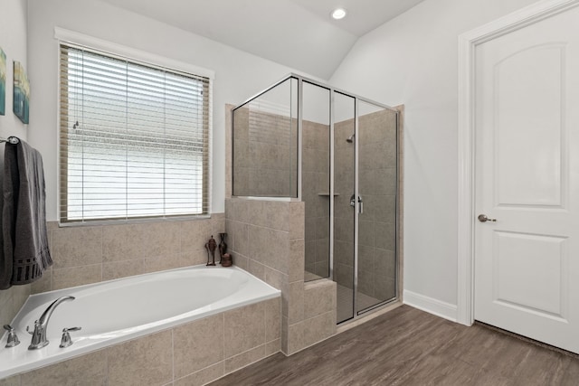 bathroom with lofted ceiling, hardwood / wood-style flooring, and plus walk in shower