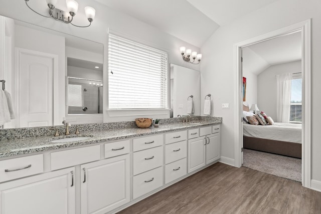 3224 Desert Shade Bnd, Leander, TX 78641 - ensuite bathroom with vaulted ceiling, a shower stall, double vanity, wood finished floors, and a chandelier