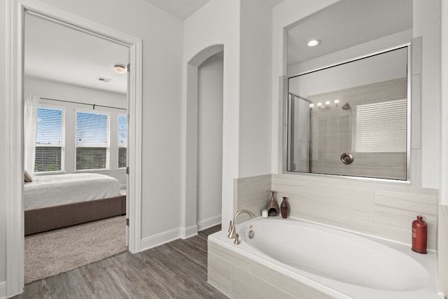 bathroom featuring hardwood / wood-style flooring and separate shower and tub