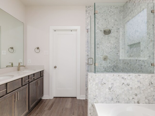 bathroom with wood-type flooring, separate shower and tub, and vanity