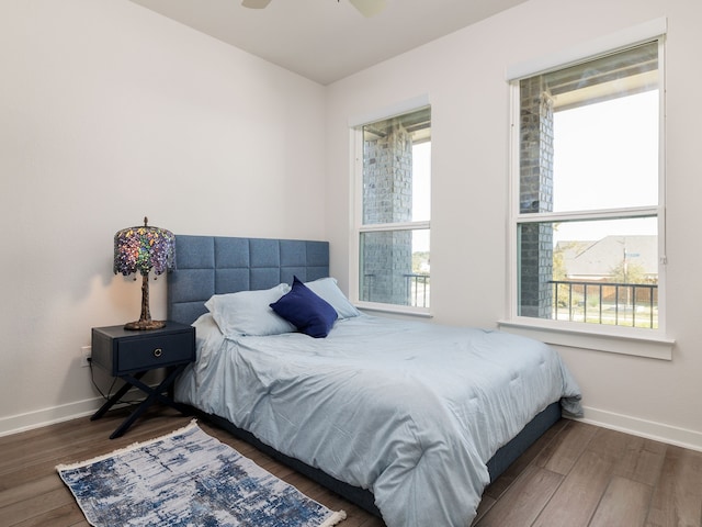 bedroom with ceiling fan, dark hardwood / wood-style floors, and multiple windows