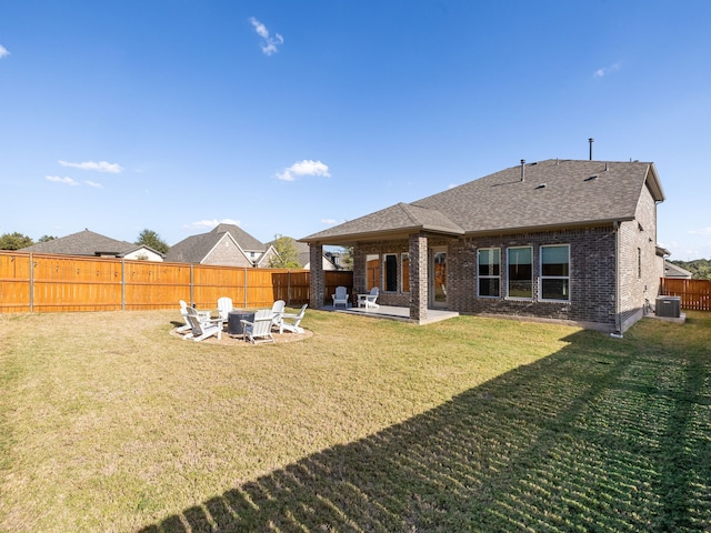 back of house with cooling unit, a yard, a patio area, and an outdoor fire pit