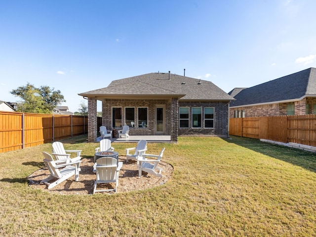 rear view of house featuring a yard and a fire pit