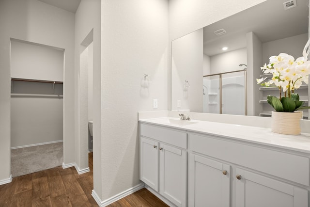 bathroom featuring vanity, hardwood / wood-style flooring, and a shower with shower door