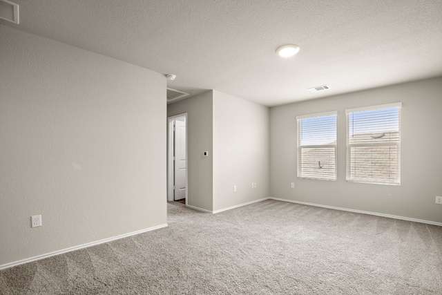 carpeted spare room with a textured ceiling