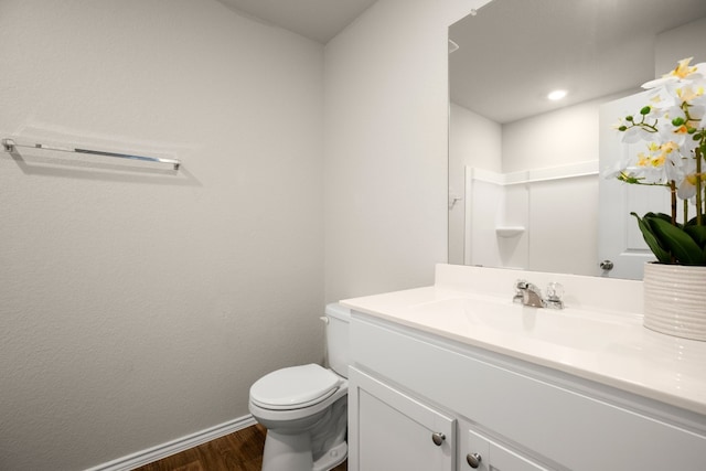 bathroom featuring vanity, toilet, and hardwood / wood-style flooring