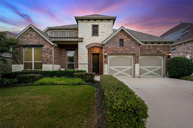 view of front of home with a garage and a yard