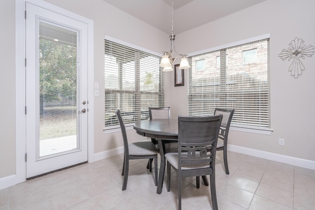 tiled dining room with a chandelier