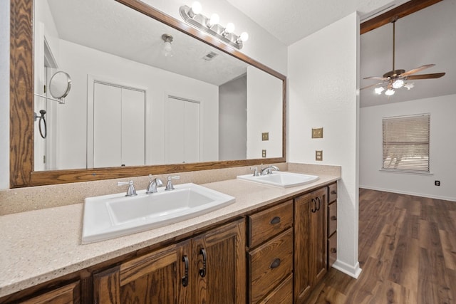 bathroom featuring vanity, ceiling fan, hardwood / wood-style flooring, and a textured ceiling