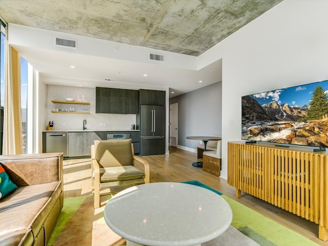 living room with light hardwood / wood-style floors and wet bar