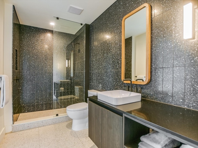 bathroom featuring tile walls, tiled shower, and toilet