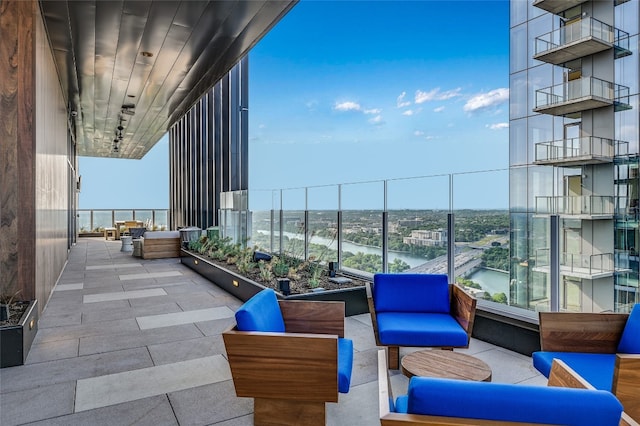 view of patio / terrace featuring a water view, an outdoor living space, and a balcony