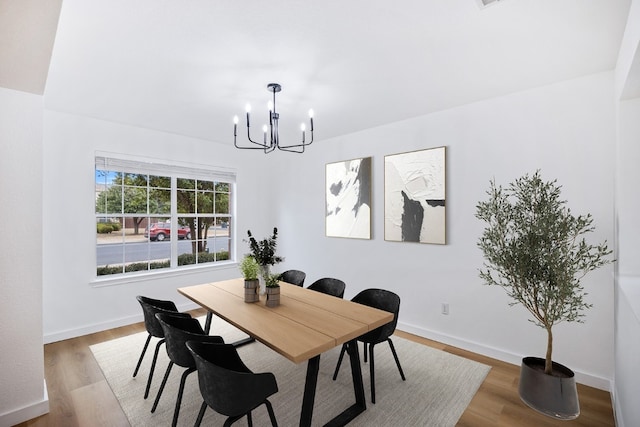 dining area featuring an inviting chandelier and hardwood / wood-style flooring