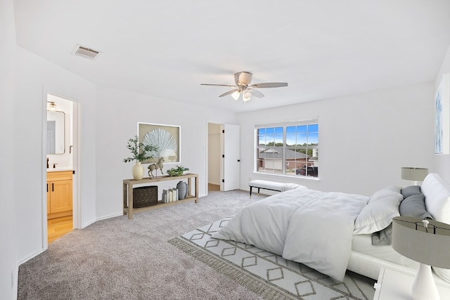 carpeted bedroom featuring ensuite bath and ceiling fan